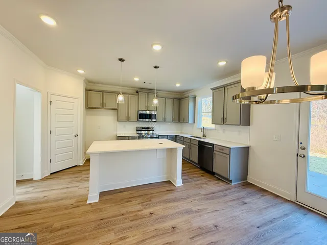 a large kitchen with a lot of counter space and wooden floor