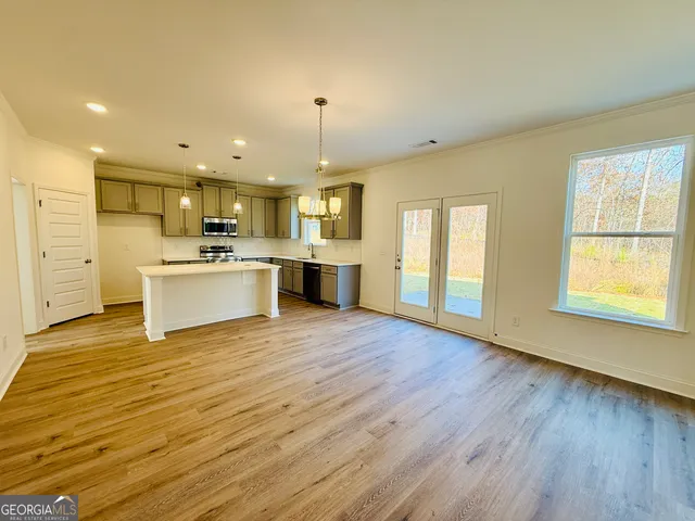 a view of a kitchen with a sink stove and wooden floor