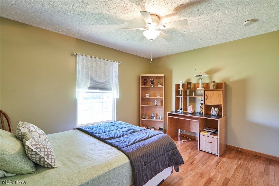 1963 Haines Road Madison, OH 44057 - Photo 20 of 34 Hardwood-finish flooring featuring a window with natural light, a ceiling fan, and light tan walls