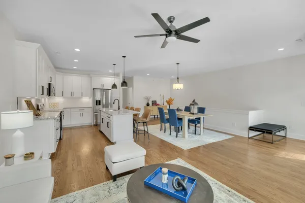 a living room with furniture and a view of kitchen