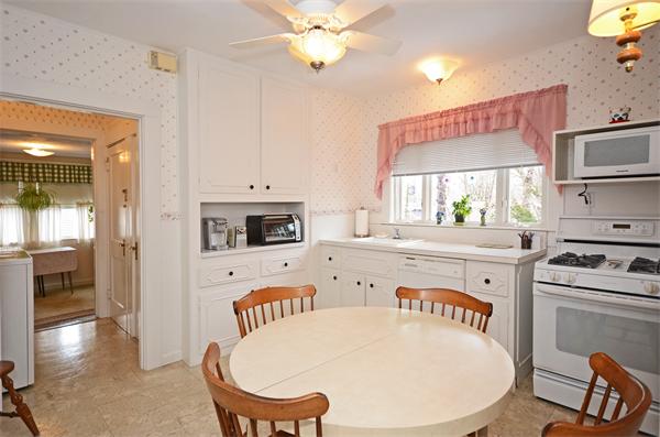 49 Katherine Road Watertown, MA 02472 - Photo 9 of 30 a kitchen with a stove a refrigerator and a dining table