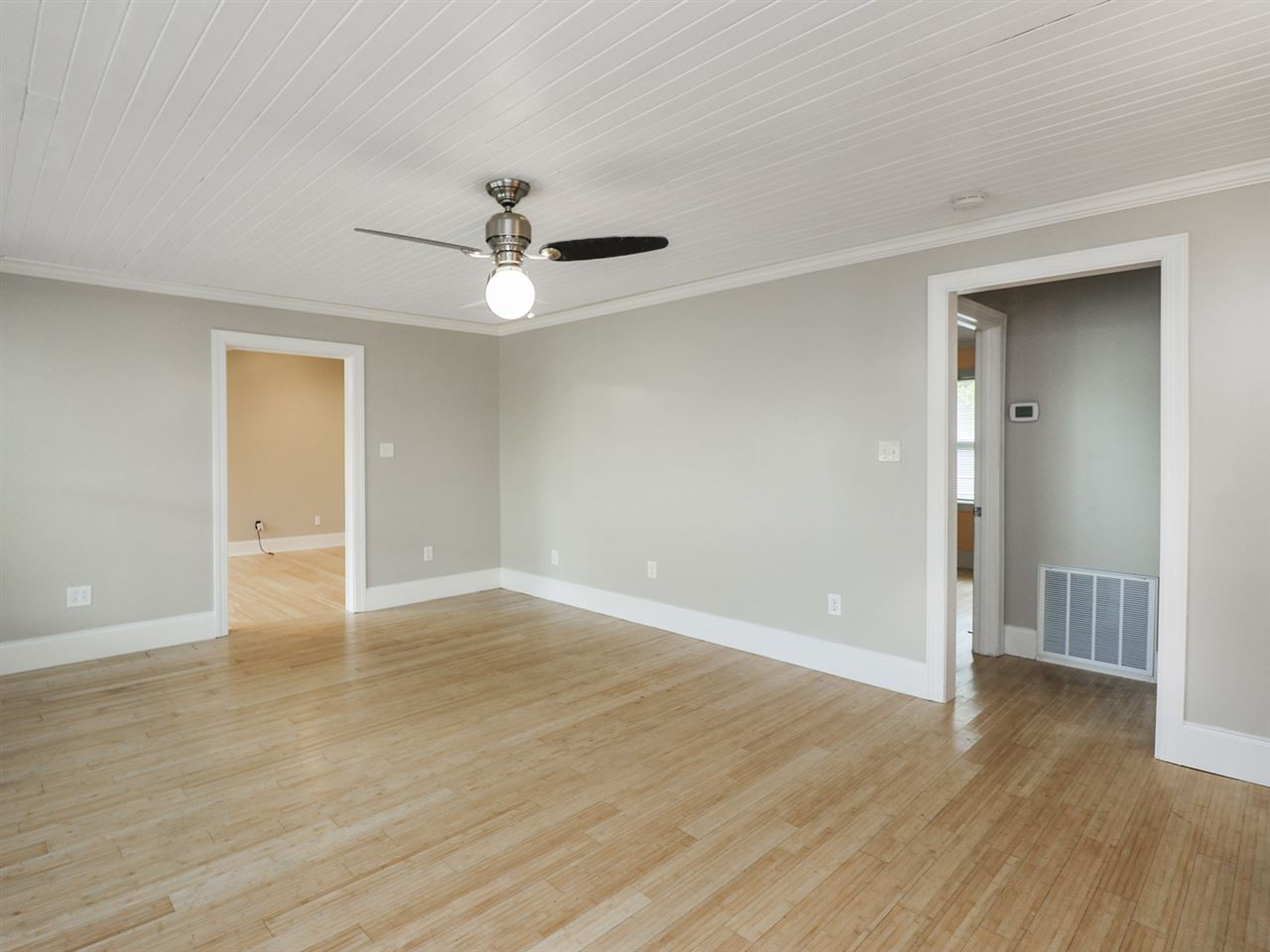 204 Proctor Street Zebulon, NC 27597 - Photo 17 of 30 a view of an empty room with wooden floor and a ceiling fan