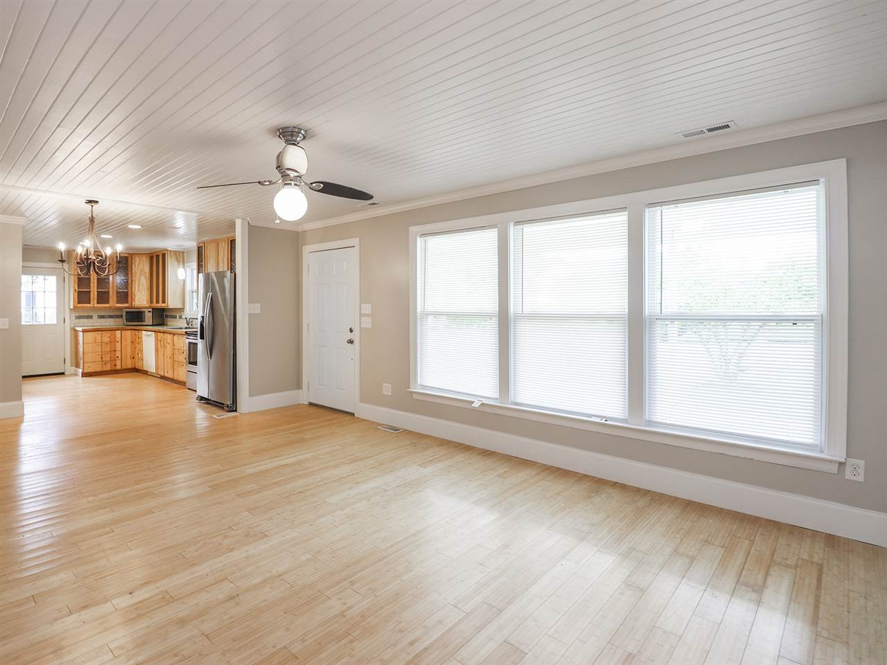 204 Proctor Street Zebulon, NC 27597 - Photo 18 of 30 an empty room with wooden floor chandelier and windows