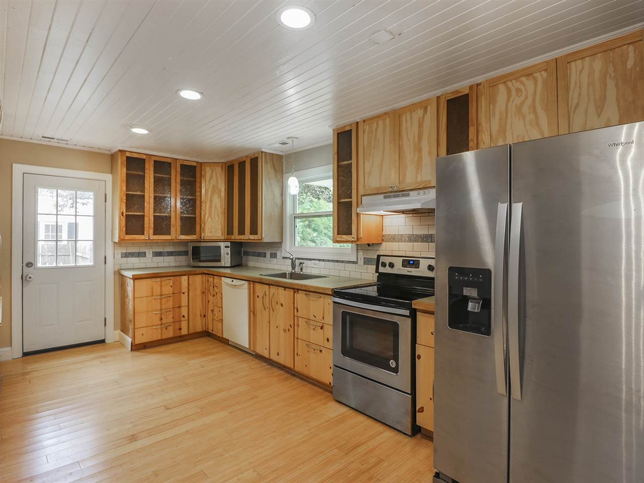 204 Proctor Street Zebulon, NC 27597 - Photo 7 of 30 a kitchen with granite countertop stainless steel appliances a refrigerator cabinets and wooden floor