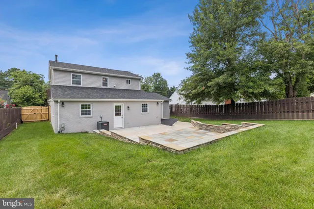 a front view of house with yard and trees in the background