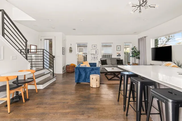 a living room with furniture a flat screen tv and kitchen view