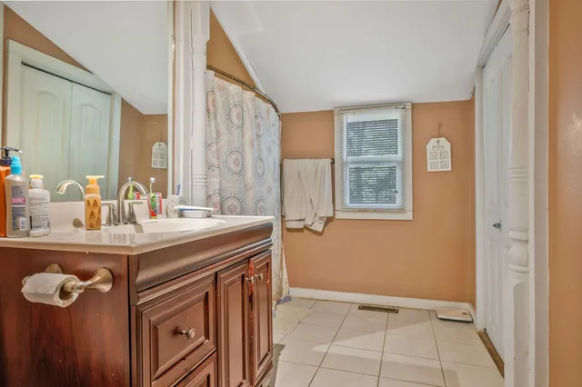 a view of a bathroom with a sink a mirror and a window