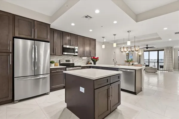 a kitchen with kitchen island a sink stainless steel appliances and cabinets