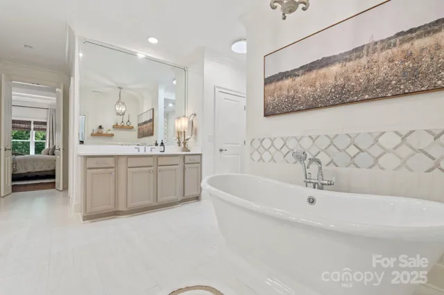 a bathroom with a tub a sink and mirror