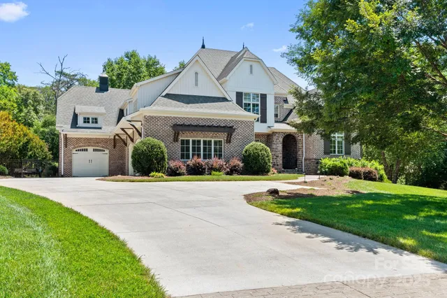 a front view of a house with a yard and trees