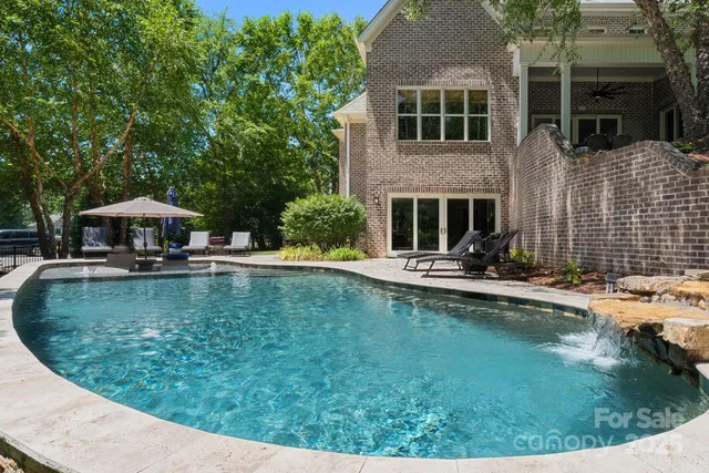 a view of a house with swimming pool and sitting area