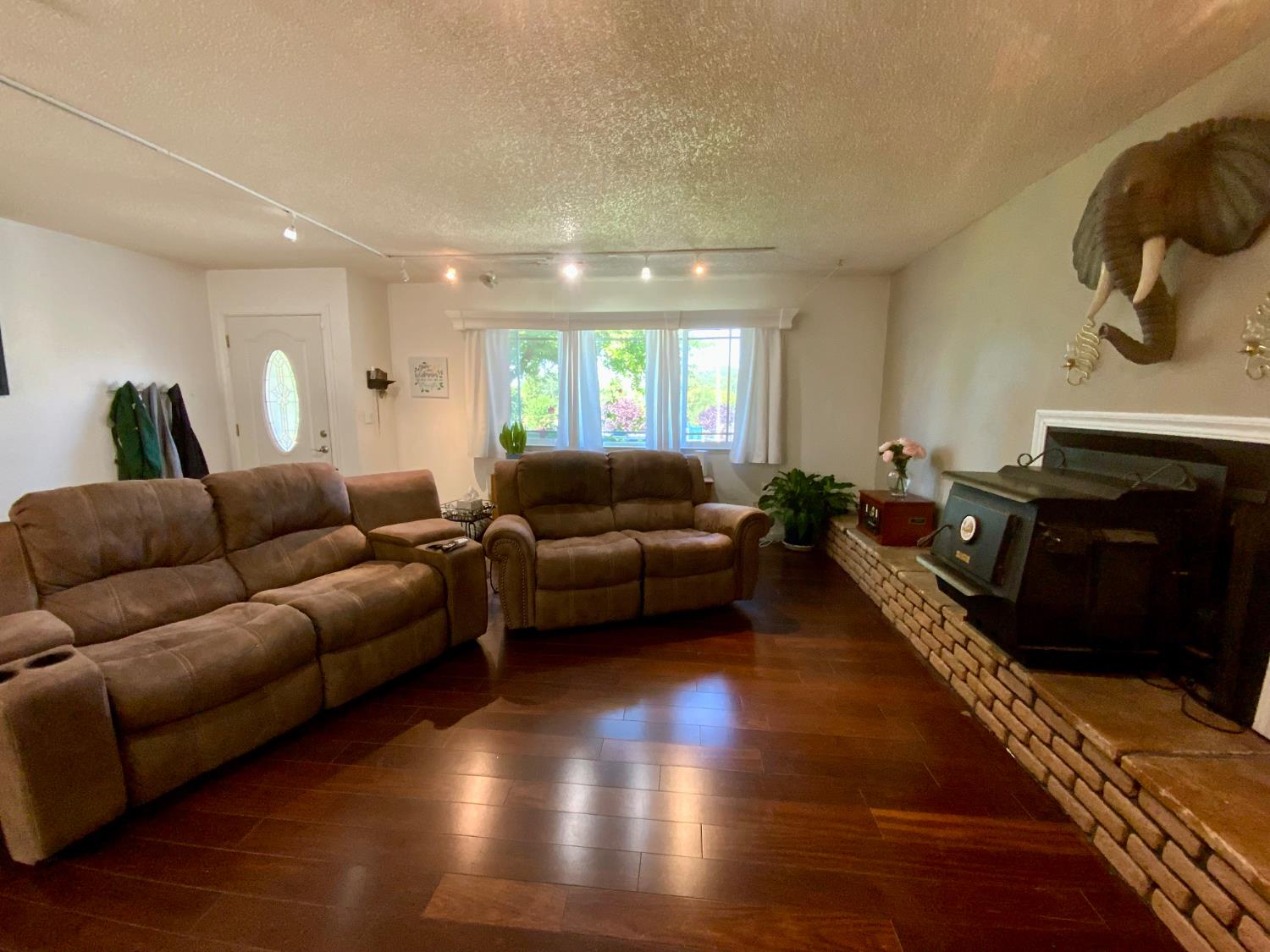 2367 Ponderosa Road Rescue, CA 95672 - Photo 13 of 76 a living room with furniture a fireplace and a floor to ceiling window