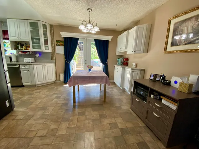a kitchen with stainless steel appliances granite countertop a stove a sink and white cabinets