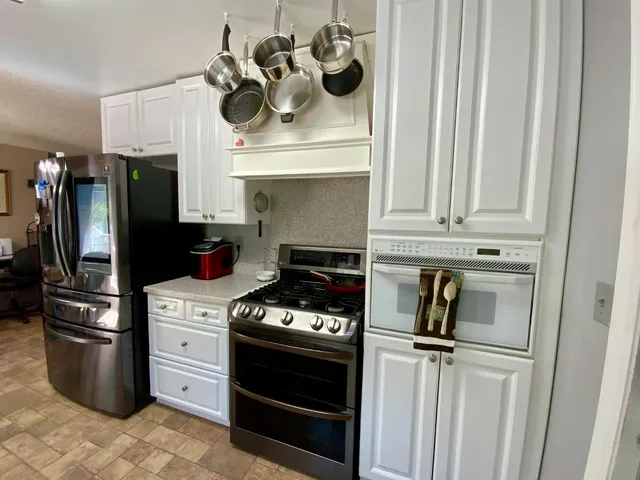 a kitchen with granite countertop a refrigerator and a sink