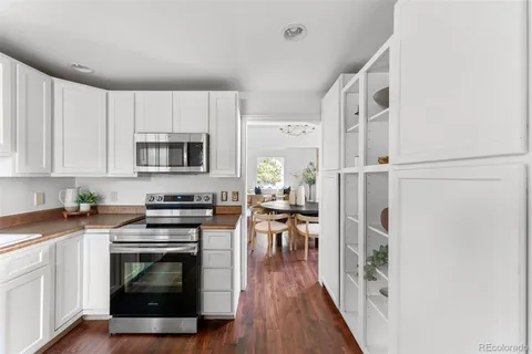 a view of a kitchen with refrigerator and wooden floor