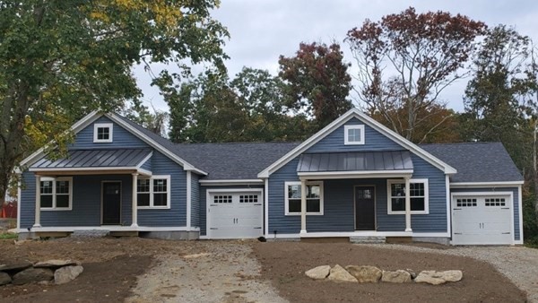 a front view of a house with a tree