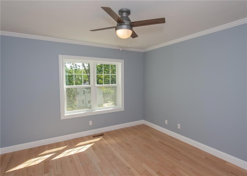 0 Bulgarmarsh Road, Unit 1 Tiverton, RI 02878 - Photo 4 of 19 an empty room with a window and a fan