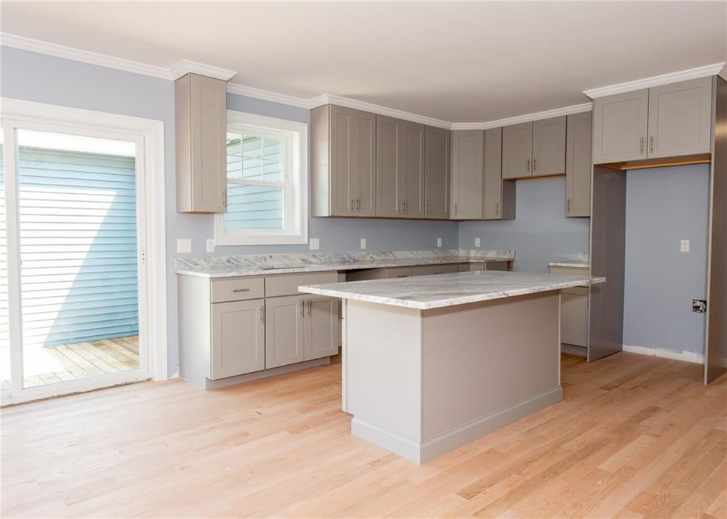 0 Bulgarmarsh Road, Unit 1 Tiverton, RI 02878 - Photo 5 of 19 a kitchen with granite countertop white cabinets and white appliances