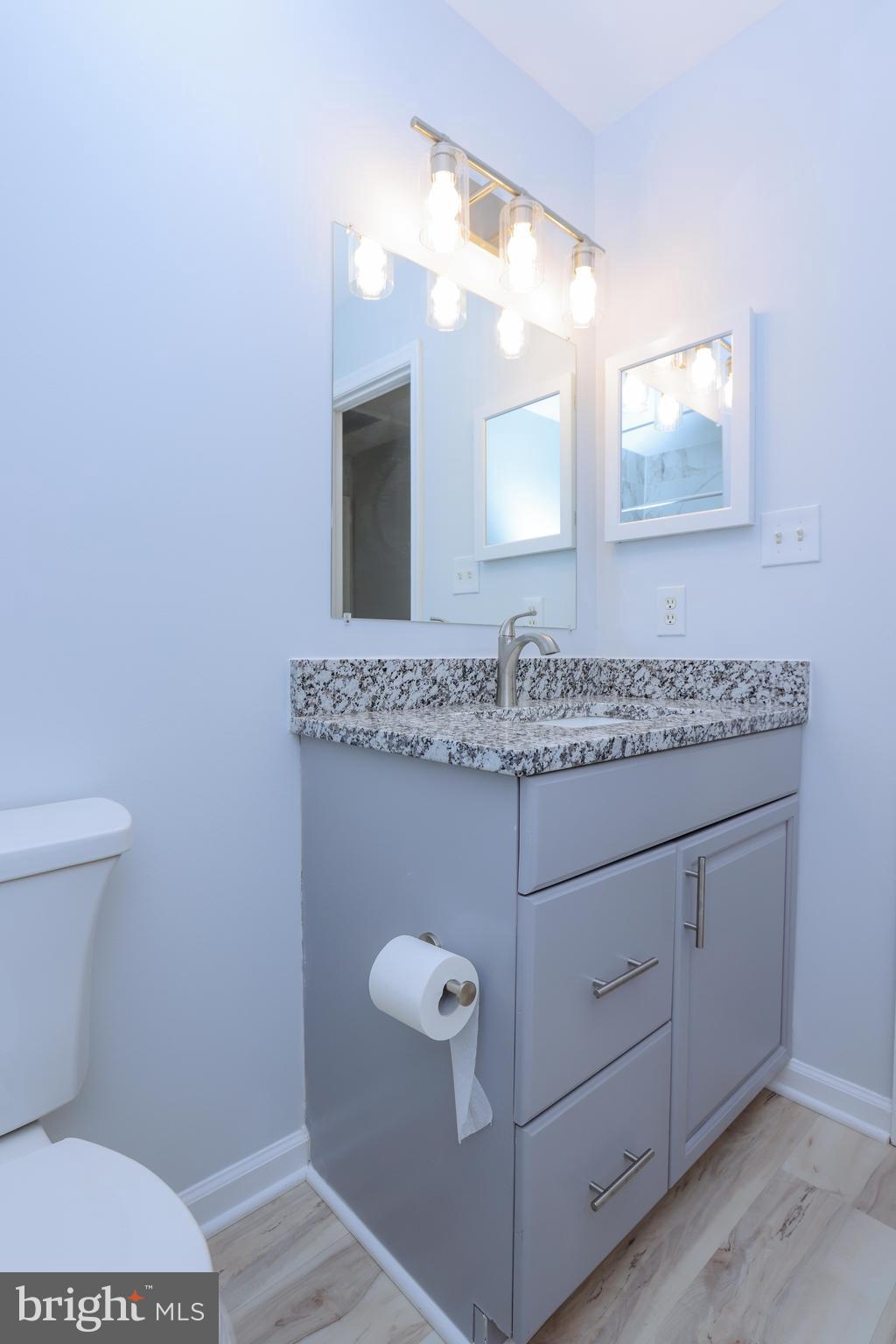 30 Queen Anne Road Glen Burnie, MD 21060 - Photo 31 of 47 a bathroom with a granite countertop sink a toilet and mirror