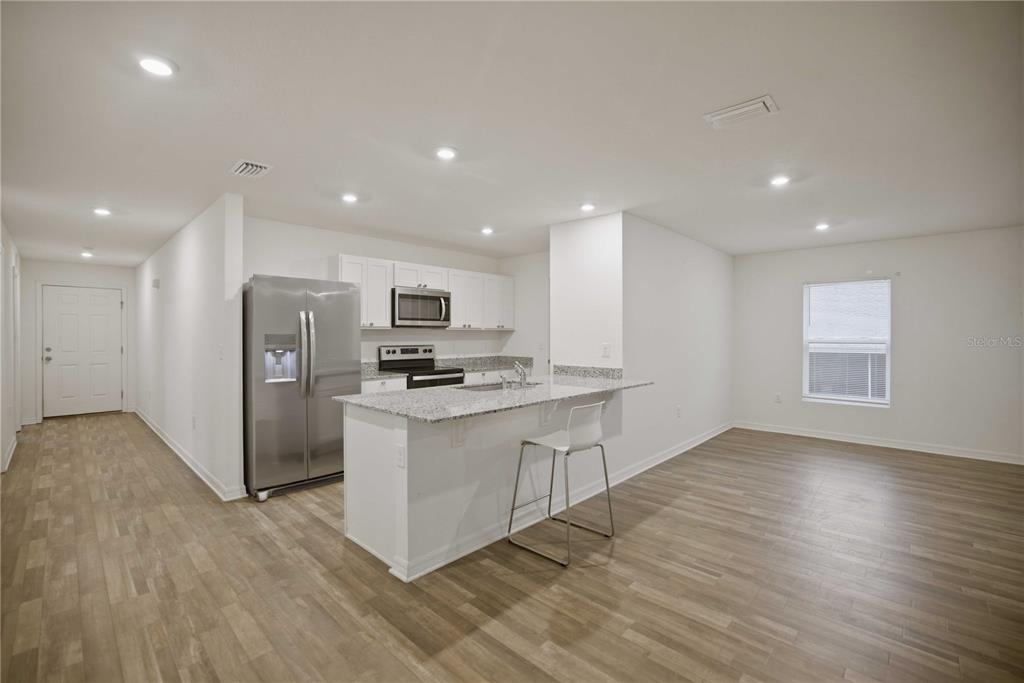 260 Emerald Road Ocala, FL 34472 - Photo 8 of 29 a kitchen with stainless steel appliances kitchen island sink refrigerator and microwave