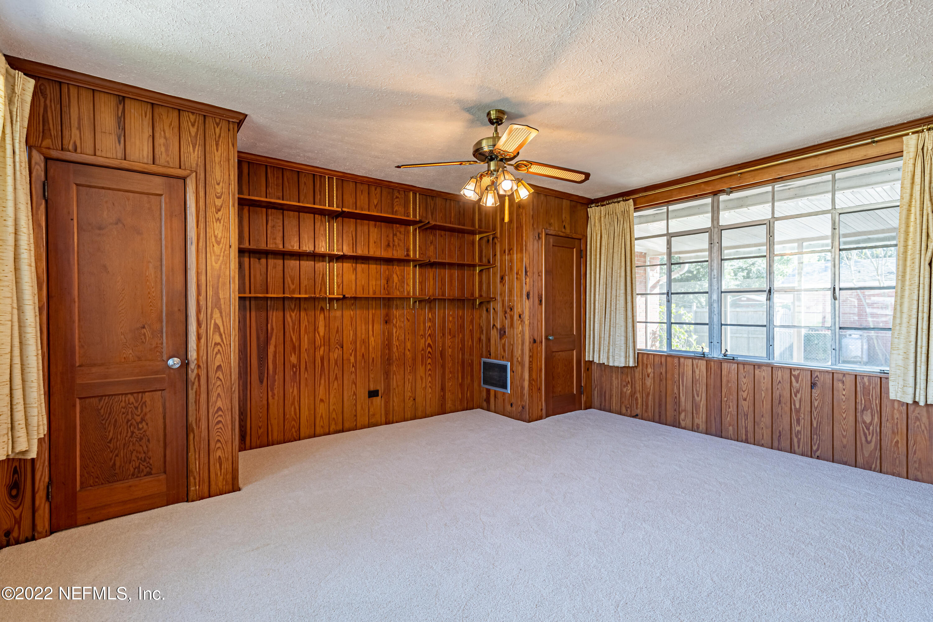 4209 Birmingham Road Jacksonville, FL 32207 - Photo 12 of 35 an empty room with chandelier fan and windows