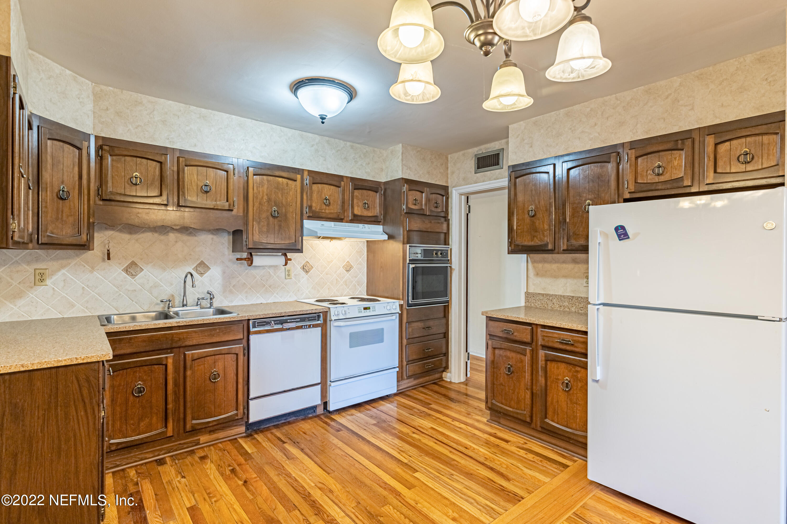 4209 Birmingham Road Jacksonville, FL 32207 - Photo 15 of 35 a kitchen with stainless steel appliances granite countertop a sink a stove a refrigerator a center island with cabinets and wooden floor