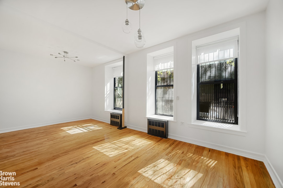29 West 119th Street, Unit 3 Manhattan, NY 10026 - Photo 1 of 14 a view of an empty room with window and wooden floor