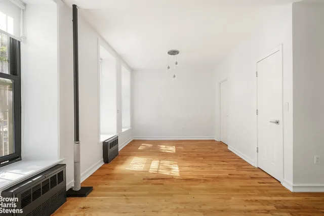 a view of a hallway with wooden floor and a window