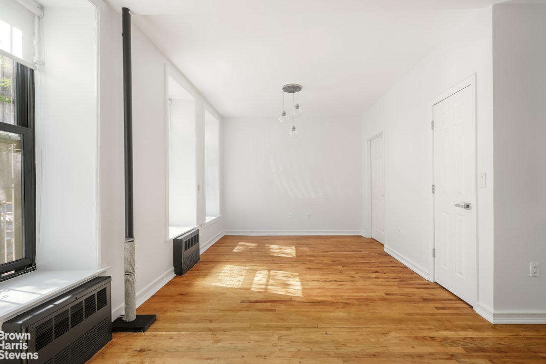 29 West 119th Street, Unit 3 Manhattan, NY 10026 - Photo 3 of 14 a view of an empty room with wooden floor and a window