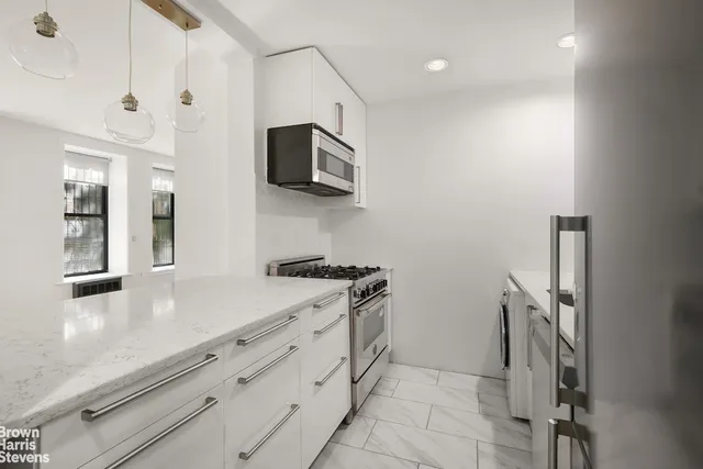 a kitchen with white cabinets and stainless steel appliances