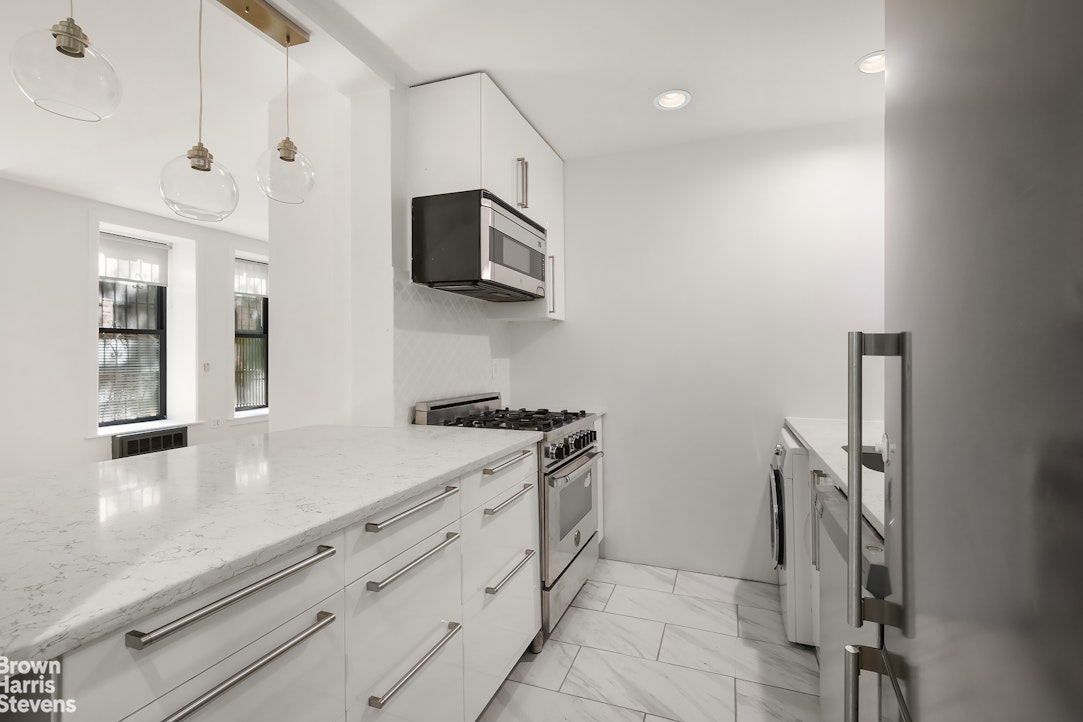 29 West 119th Street, Unit 3 Manhattan, NY 10026 - Photo 6 of 14 a kitchen with stainless steel appliances granite countertop a stove a microwave and a sink
