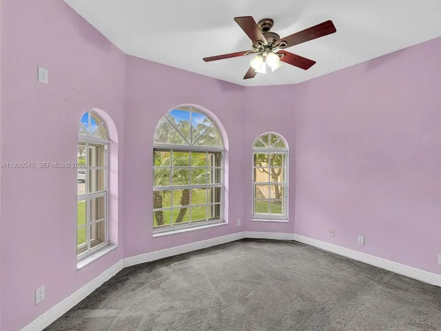 a spacious bedroom with a large bed and a chandelier