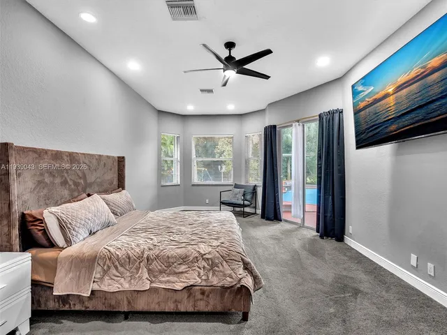 a view of an empty room with wooden floor and a ceiling fan