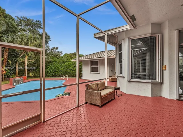an aerial view of residential houses with outdoor space and trees