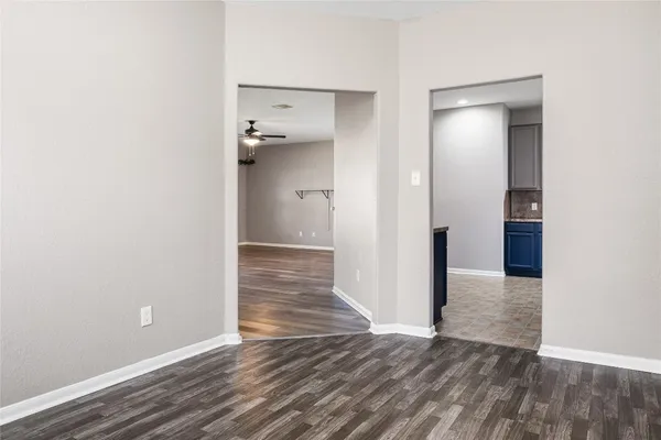 an empty room with wooden floor & windows