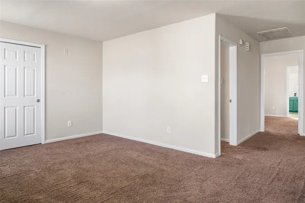 an empty room with windows and cabinet