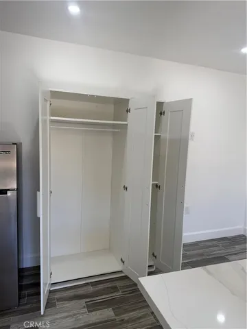 a view of a hallway with wooden floor and closet