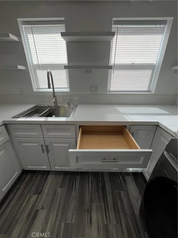 a view of a kitchen with a sink and wooden floor