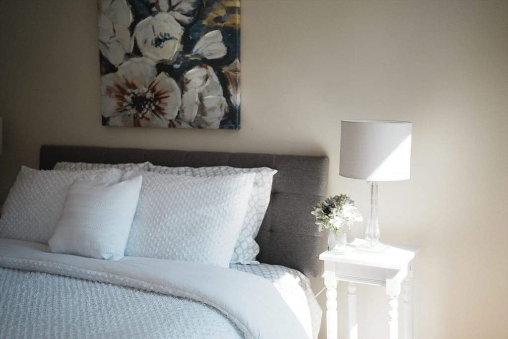 28 Juniper Street, Unit 79 Brookline, MA 02445 - Photo 13 of 23 a bedroom with a bed and a lamp