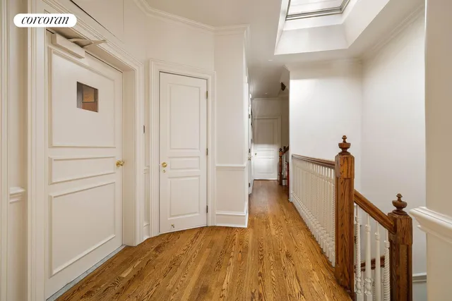 a view of a hallway with wooden floor and staircase