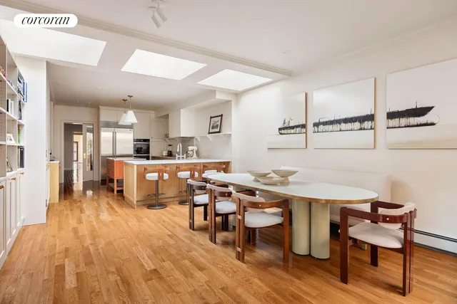 a living room with stainless steel appliances kitchen island a table and chairs in it
