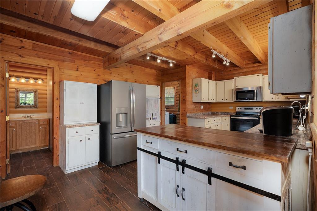 1001 Liberty Church Road Northeast Ranger, GA 30734 - Photo 20 of 40 a kitchen with stainless steel appliances granite countertop a refrigerator a sink dishwasher a stove and white countertops with wooden floor