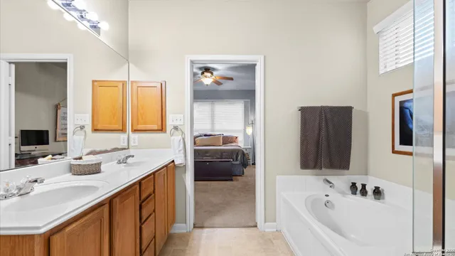 a en suite spacious bathroom with double vanity a mirror and a bathtub
