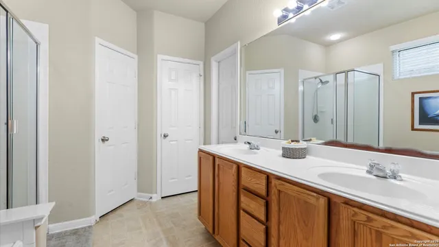 a bathroom with double sink and a mirror