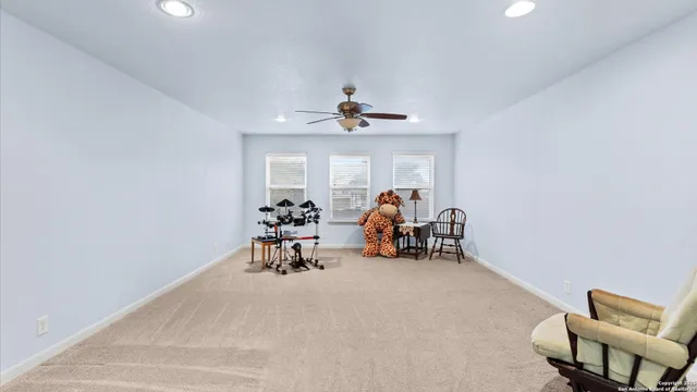 a view of a room with furniture and a ceiling fan