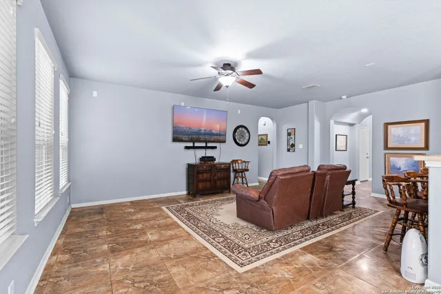 a living room with furniture a flat screen tv and a window