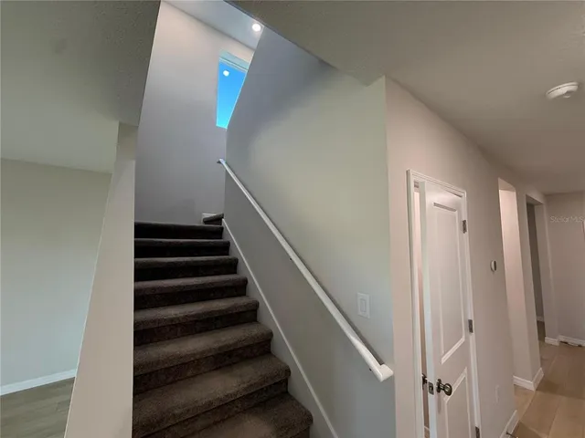 a view of a big room with windows and chandelier fan