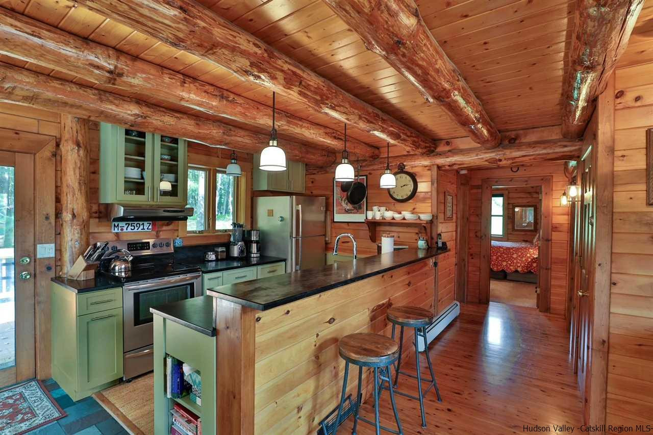 391 Tumbleweed Ranch Road West Kill, NY 12492 - Photo 11 of 35 a kitchen with stainless steel appliances granite countertop swimming pool table and chairs