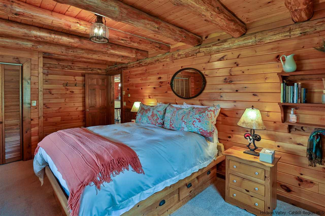 391 Tumbleweed Ranch Road West Kill, NY 12492 - Photo 15 of 35 a bedroom with a bed and a chandelier