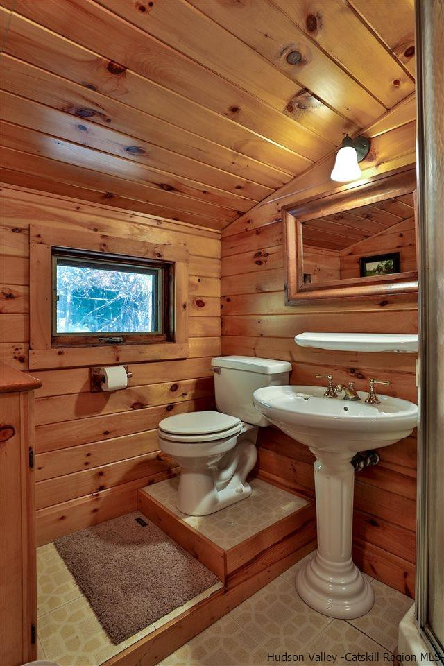 391 Tumbleweed Ranch Road West Kill, NY 12492 - Photo 22 of 35 a bathroom with a sink a toilet and a shower curtain